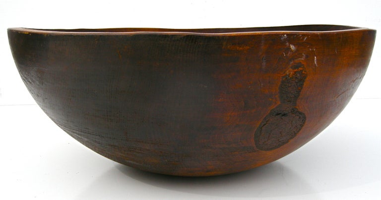A simple yet subtly handsome vintage wooden bowl. Hand-carved and crafted. Showing a time worn and weathered overall surface and patina from years of perpetual wear and usage. Rustic elegance and style. Southern origins.