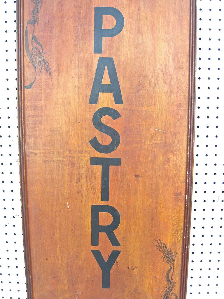 A terrific, vintage, advertisement sign from Midwestern country store and/or bakery.  Hand painted with decorative stenciling adornment. Original time worn lacquer finish and patina.