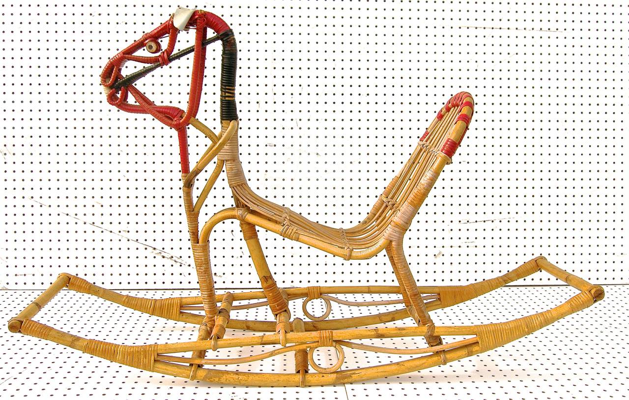 A terrific, Danish designed, Mid-Century, rocking horse. Hand constructed of woven rattan and brightly colored leather accents/adornments. Sculpturally playful.