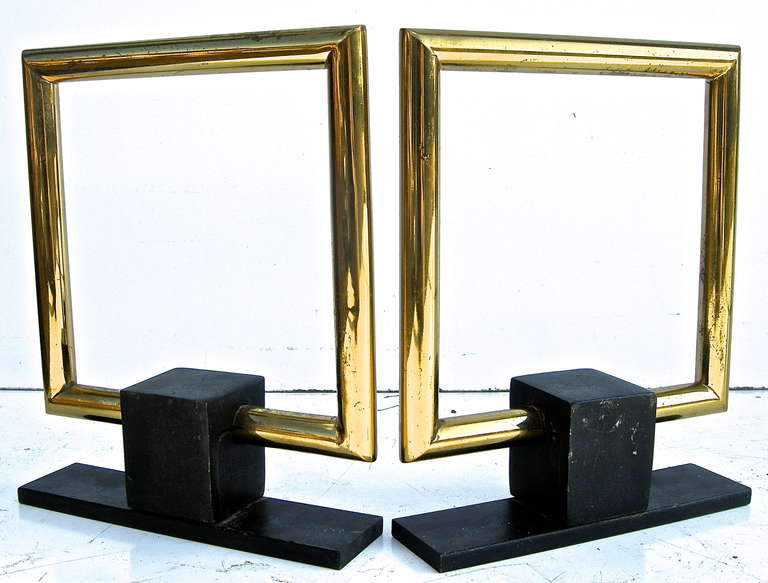 A striking pair of vintage, moderne style chents in bold brass buckle motifs.  Beautiful stand alone fireplace accessories.