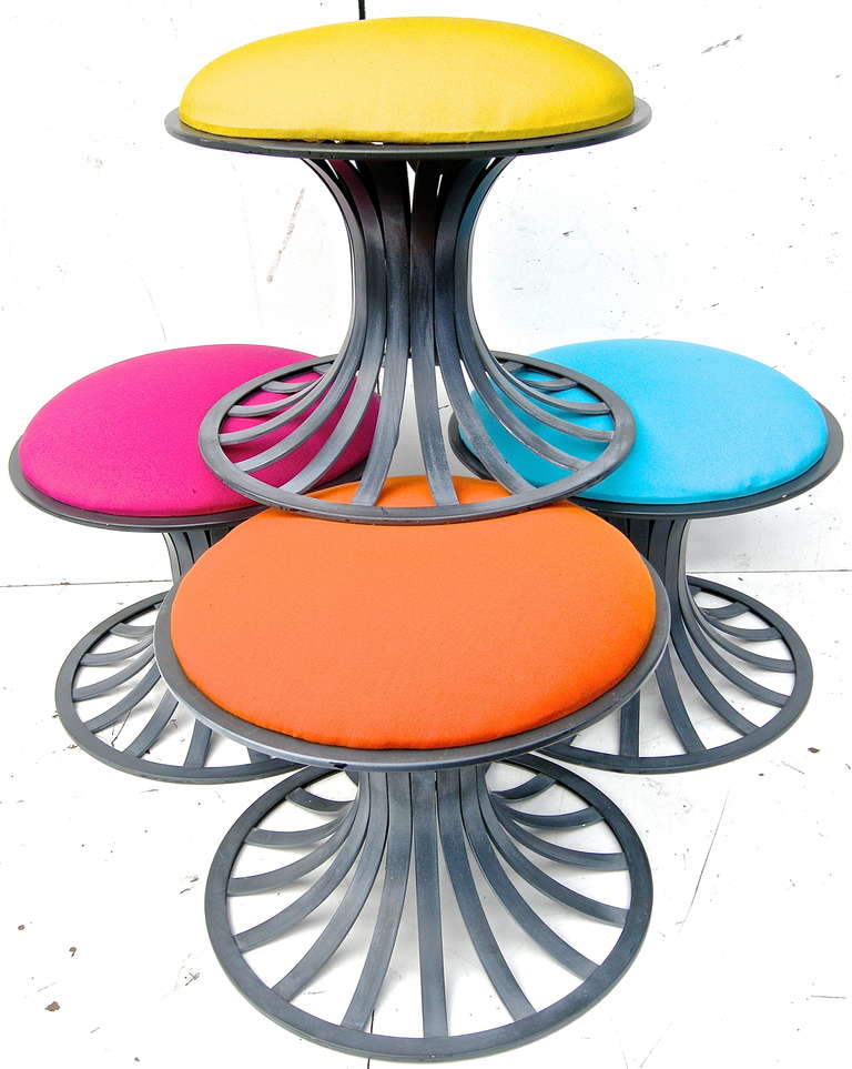 Unique set of highly visual, vintage stools attributed to the Woodard Furniture Company. Crafted of lightweight aluminum into highly sculptural shapes and forms. Topped with striking all weather upholstered tops in a vibrant multi-color palette.