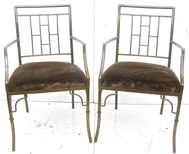 Unique pair of vintage, Billy Haines attributed, armchairs. Having striking shapes and forms with geometric, rectangular-patterned backs with sloping arms and Haines-style decorative leg brace accents.  Elegant distressed, aged silvery-brass,