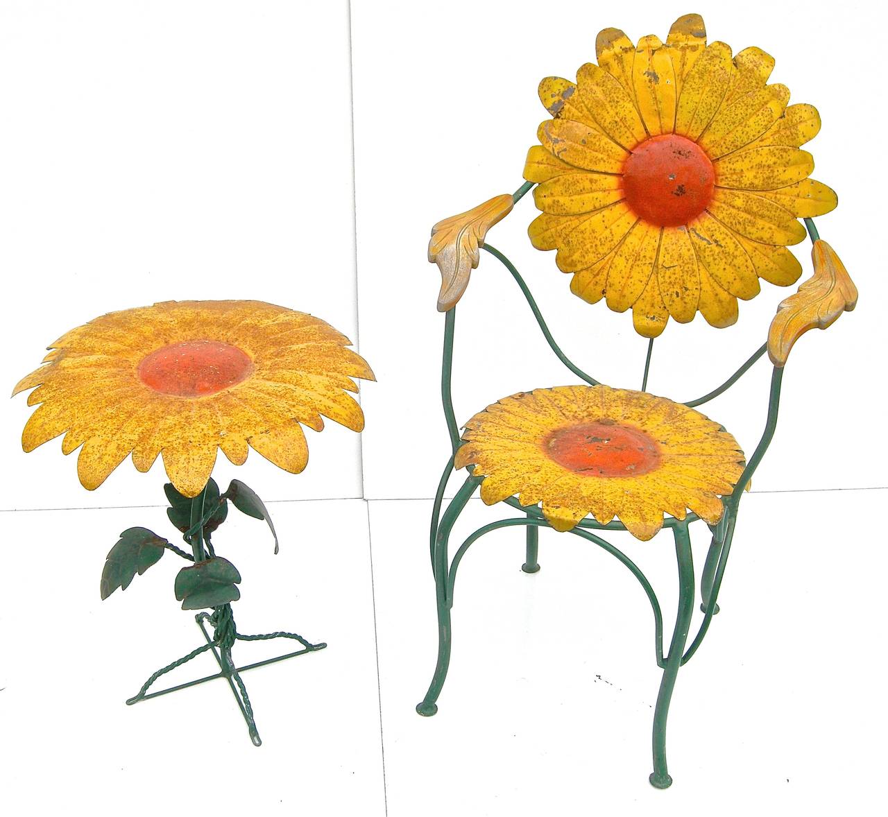 Terrific, vintage, cast iron garden set having a whimsical and eye catching sunflower/daisy motif. Warm time worn and weathered, semi-distressed surface and patina. Attributed to John Vessey.