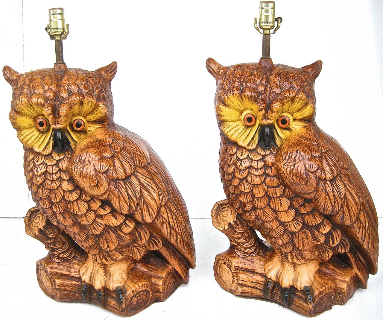 Wonderful pair of striking, vintage, overscale lights in bold owl motifs. Graphic shapes and forms with vivid detailing. Cast ceramic with original paint. Penetrating, lifelike, glass eyes. H to top of head: 21