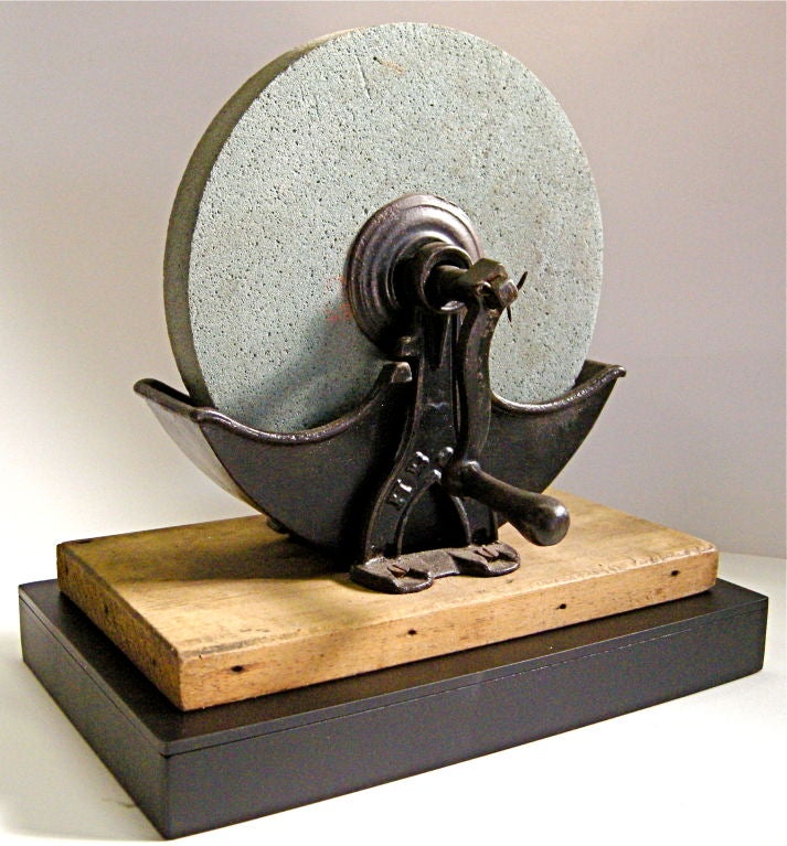 An extremely handsome and unique, small scale grinding wheel/stone. Most likely originated from an early Midwestern general/dry goods store. Having an unusual small scale and shape with strong, clean lines projecting a bold sculptural and