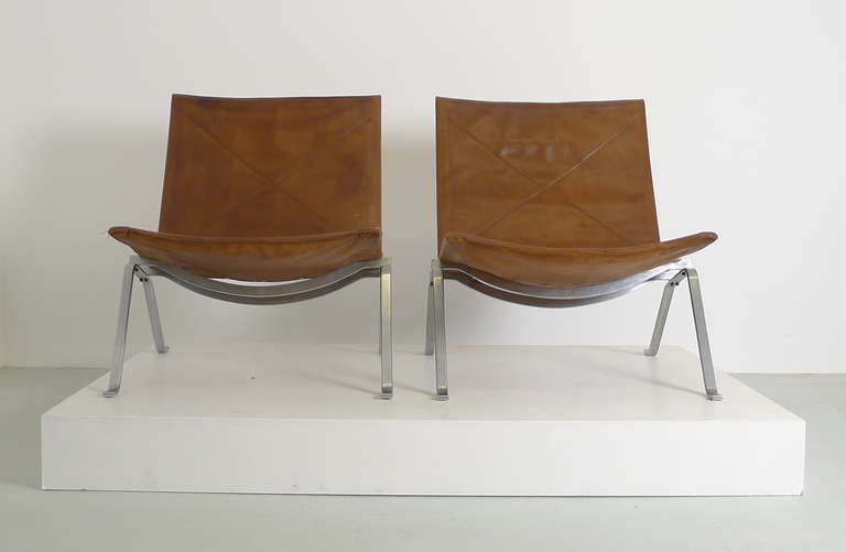 Poul Kjaerholm for E Kold Christensen, an early pair of PK-22 chairs in original chocolate brown leather over steel frames . Signed with makers marks to each example .

Leather restored and strengthened from below .