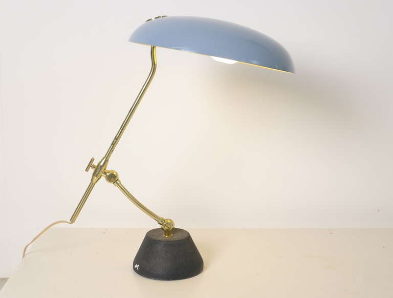 A 1950's Italian desk lamp , solid cast base with textured black finish very much in the style of several Arteluce floor lamps , brass arm in two sections and a duck egg blue shade . The lower arm pivots at the base , the upper arm adjusts in length