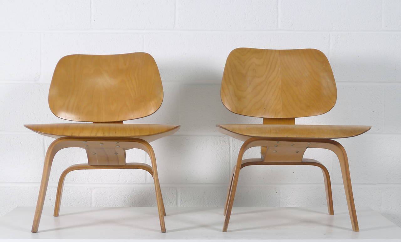 Charles and Ray Eames for Evans Molded Plywood Division, 1948. A pair of matched LCW's, these chairs have always been together. They have the 5-2-5 screw pattern and the labels to date them to 1948. 

Excellent vintage condition with all original