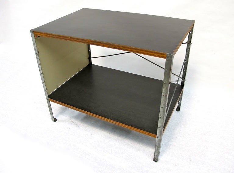 Charles and Ray Eames ESU model 100-C manufactured by Herman Miller.  This unit features one neutral Masonite panel and black laminate surfaces. Signed with decal manufacturer’s label to interior: [Herman Miller Furniture Company Zeeland Michigan