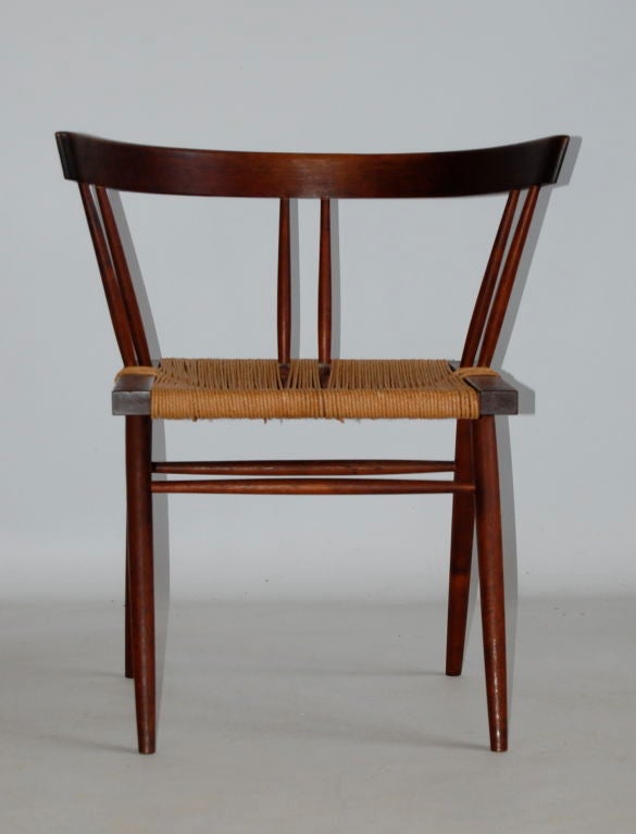 George Nakashima studio made Grass Seat chair of solid walnut construction  . Curved back rail over square seat supported on tapering legs .