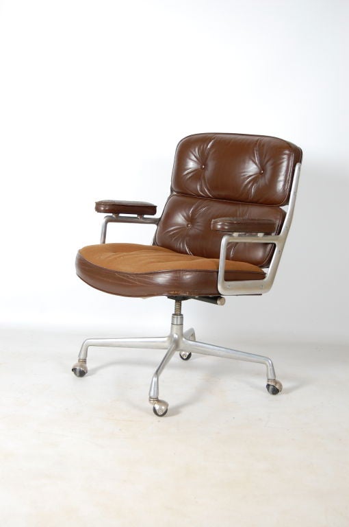 A Charles and Ray Eames for Herman Miller desk chair for the Time & Life building in New York , chocolate brown leather backrests and arms with tan cloth seat . Tilt , swivel and height adjustable , 4 star base with castors .