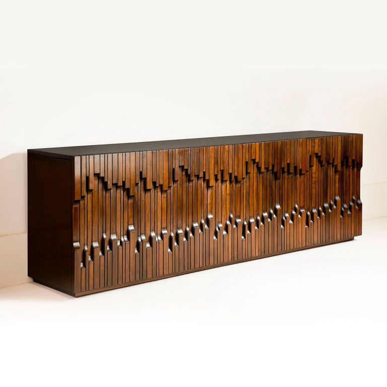 Stunning four door cabinet in exotic African hardwood  designed by Luciano Frigerio, the doors opening to reveal shelves within.The central door opens to reveal five drawers. The door design was created to resemble a piano keyboard.<br />
Item