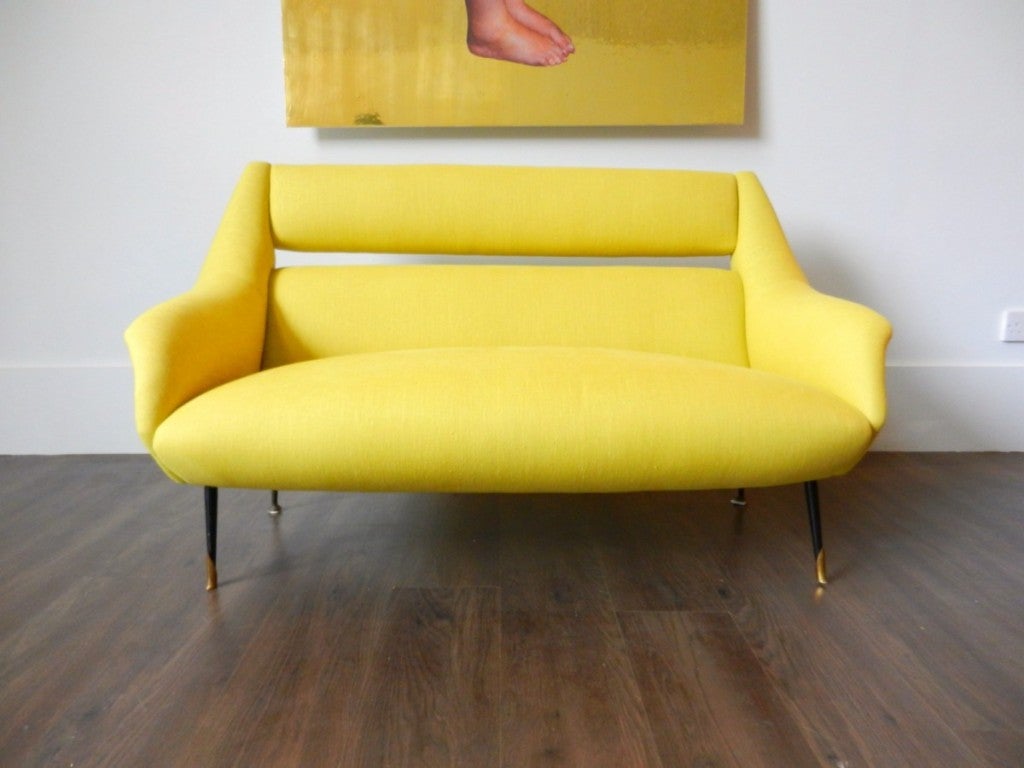 Angular small Italian sofa with black lacquered metal legs with brass sabots. Reupholstered in yellow linen.