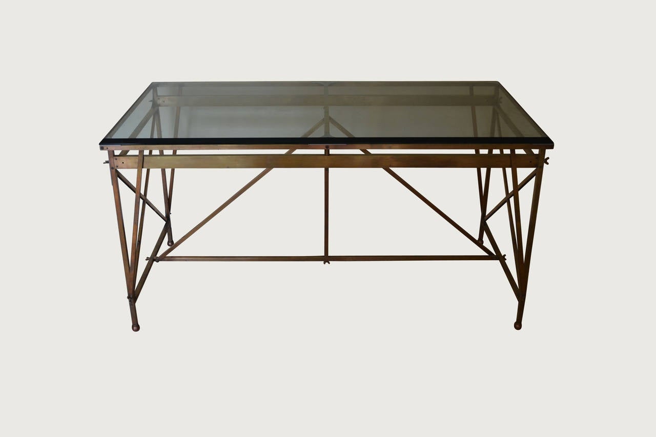 Lacquered brass architectural desk with steel mounts and thick, clear
bevelled glass top. This desk is symmetrical in design and can
be sat at from both sides.