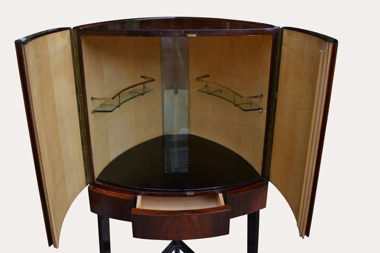 Very elegant freestanding two door rosewood bar.  The interior is fitted with black glass, two shelves and a light.  On the outside there is a drawer to the front and glass shelf at the bottom.