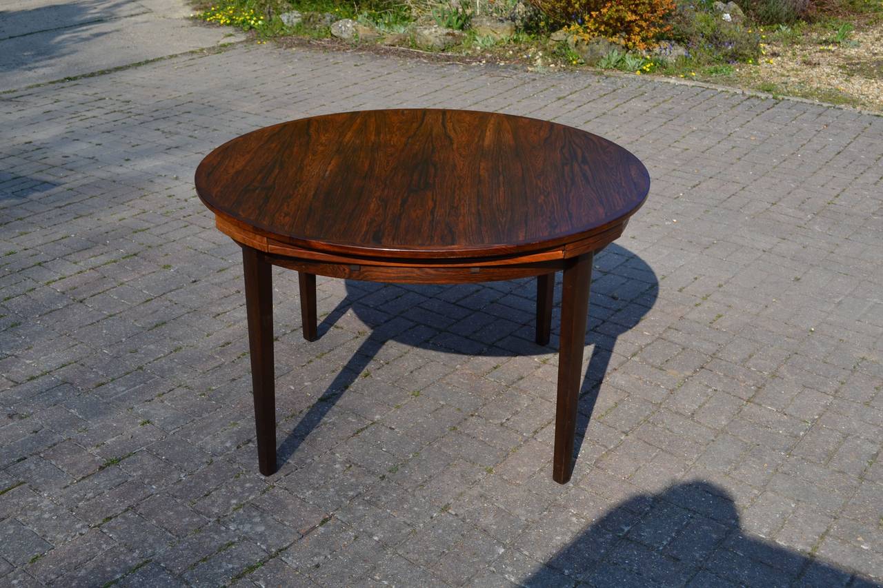 Rosewood extending Lotus or Flip-Flap dining table 
with lacquered brass hinge detail, manufactured by Dyrlund.