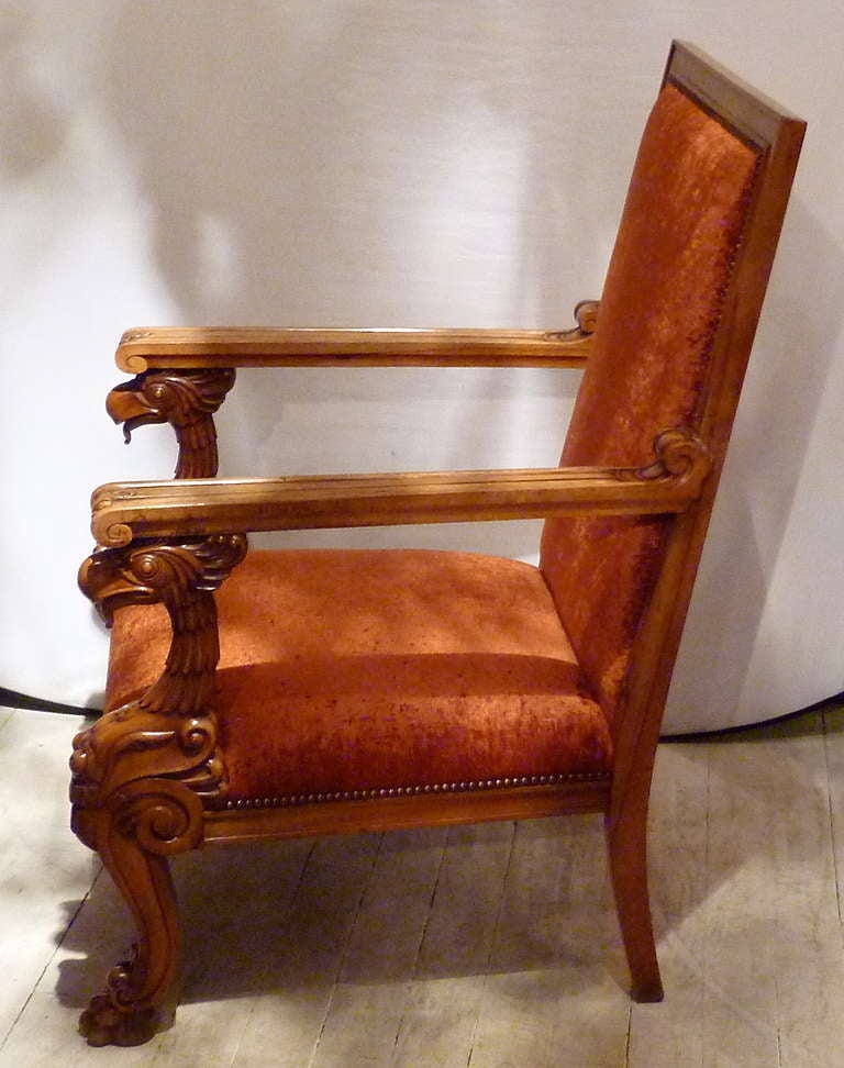 A fine pair of flamboyantly designed large pale mahogany high back armchairs, Ireland, circa 1840. Intricately carved all-over with fluted and tapering arms supported by wonderful griffon’s heads, above sabre legs on carved paw feet. Reupholstered