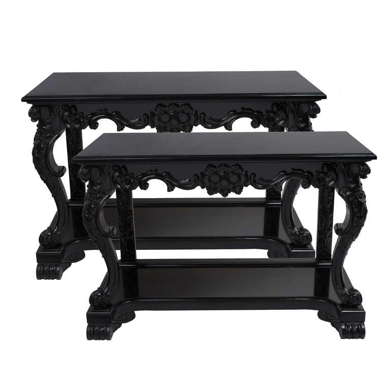 Pair of very handsome Anglo Indian ebonised free standing console tables with later black marble tops. In the rococco style, the finely carved floral and foliate apron above matching legs, the front two of cabriole form. Supported on rectangular