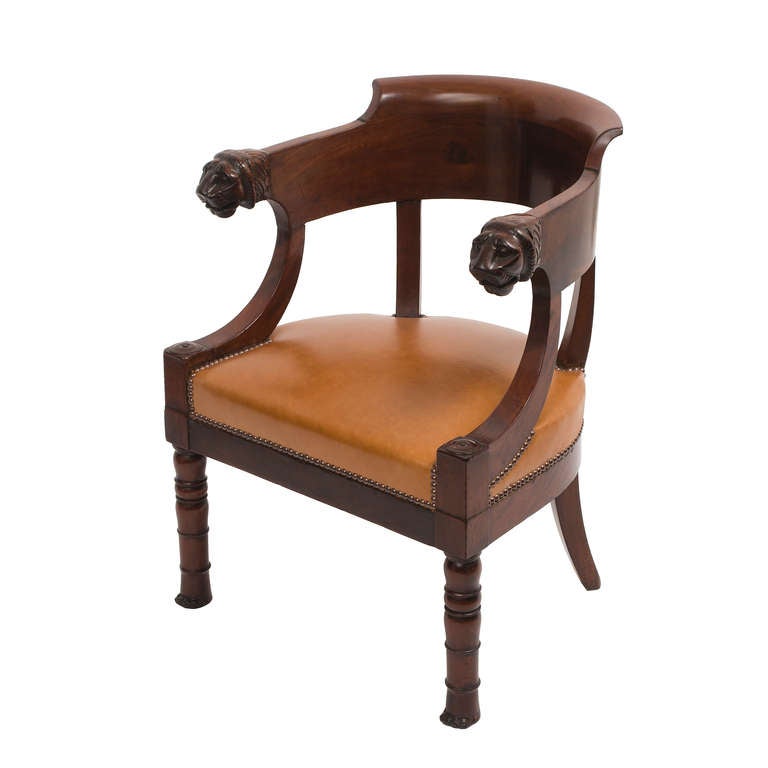 A very fine French Empire mahogany 'Fauteuil de Bureau' c.1820, in the manner of Jacob Freres. The arm terminals carved as lions heads above ring turned baluster legs with delightful paw feet.
Traditionally re-upholstered in cognac coloured leather.