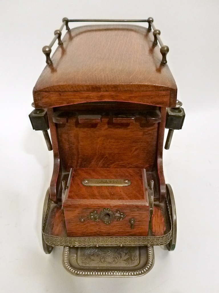 A charming, beautifully made Victorian oak smoking & gaming compendium in the form of a period delivery carriage. With removable brass carriage lamps, spoke wheels and other brass fitments, the top opens to reveal a pressed metal ashtray and