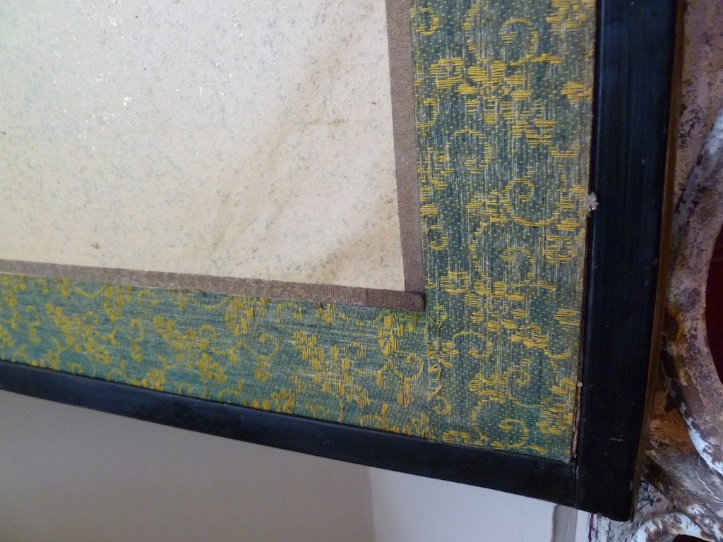 Large Gold Ground Six Panel Japanese Paper Screen decorated with white Cranes perching on a tree. The border of the screen is in a filigree design of gold and green fabric with a black lacquered wood edge with brass corner mounts.
The back of the