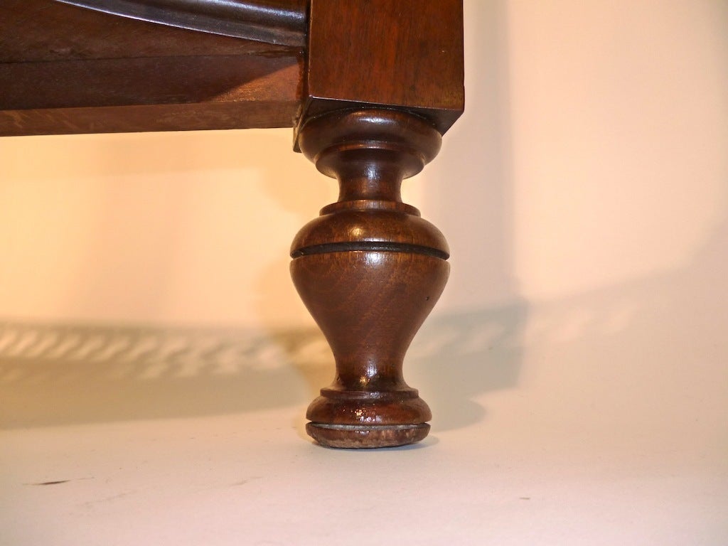 A late Victorian mahogany Silver table in the Georgian Neo-Gothic style with cluster column legs and turned feet. The pierced frieze displays a keyhole design, which is repeated as a gallery along a concave shaped shelf. 

Due to the rising