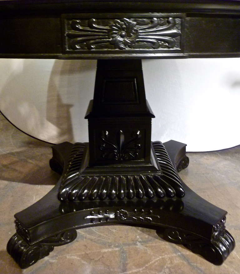 A striking and very fine Anglo Indian ebonised Regency style centre table. India, c.1850.
 The beautifully veined, original white marble top above an apron carved with eight flowers, supported by a square tapering column adorned with carved