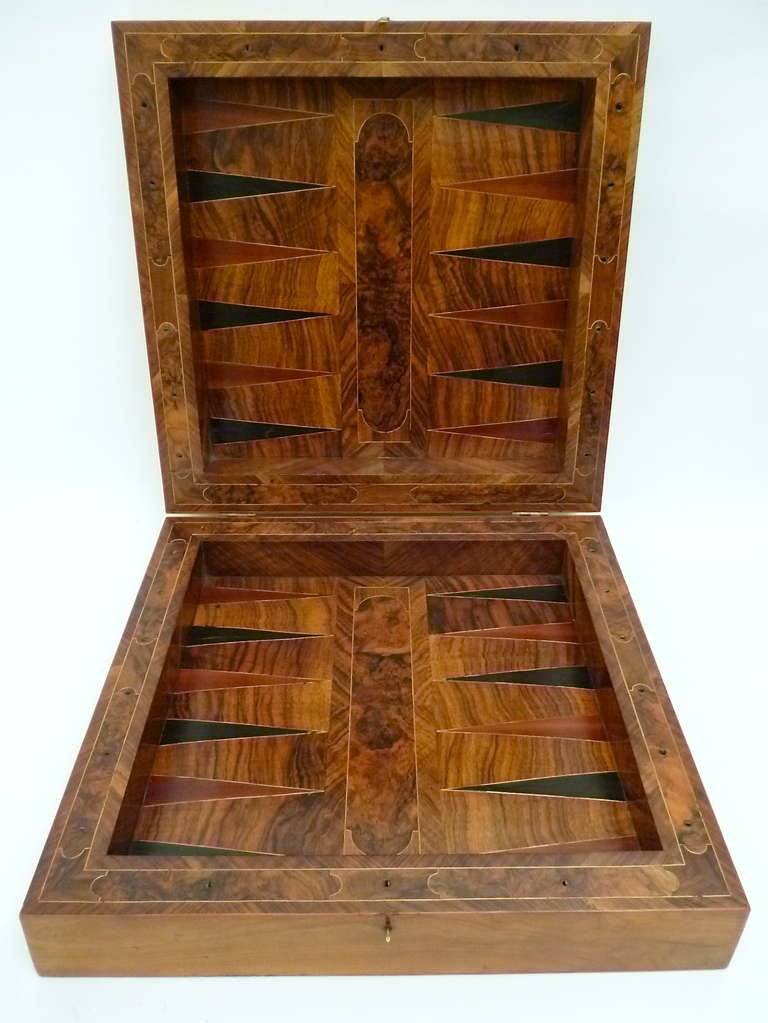 A fine Italian walnut & fruitwood parquetry games box with ivory & ebony counters c.1840.
The cherrywood veneered outer frame with chessboard inlaid with olivewood and fruitwood.
The inside backgammon board including inlays of burr walnut,