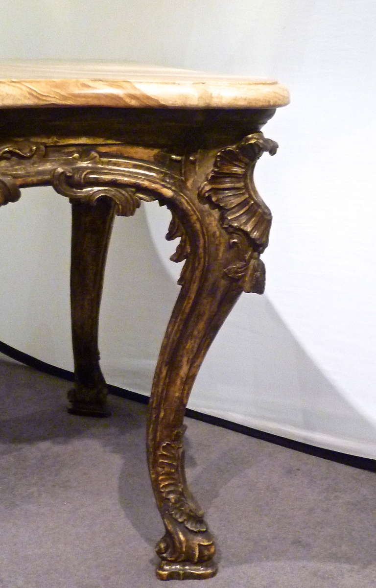 A wonderful Venetian centre table c.1770.
The later 19th century shaped highly figured 'Alabatro Fiorito' top, supported by a sinuously carved base with exaggerated cabriole legs and highly carved aprons with foliate detailing throughout. The table
