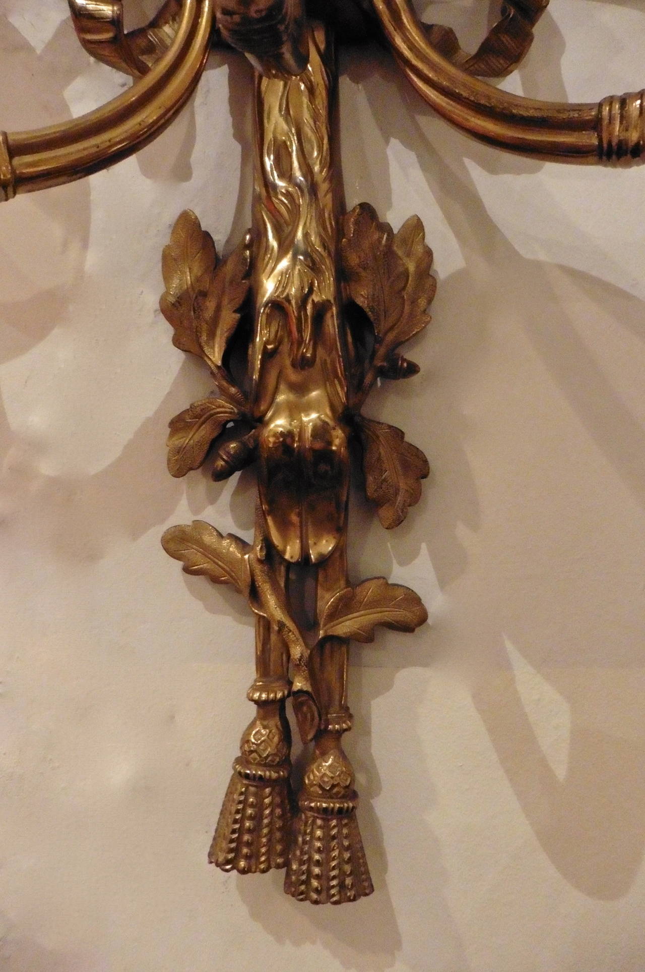 A fine set of six French gilt bronze three light wall sconces c.1910. Flamboyantly designed with  arms in the form of hunting horns and the backs with cast tassels and deer’s foot motifs.  (UNWIRED)