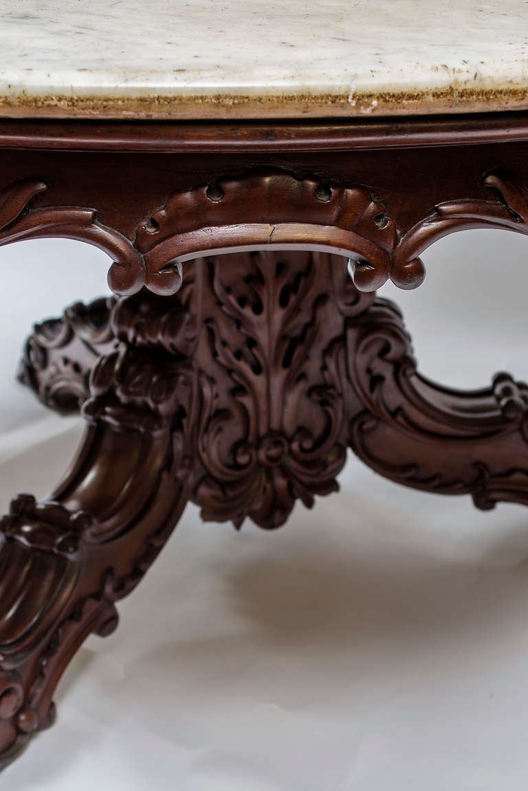 Anglo Indian Rosewood centre table. The original white and grey marble top above an apron, central column and tripod base all richly and boldly carved with scrolled acanthus decoration. Mid 19th Century.