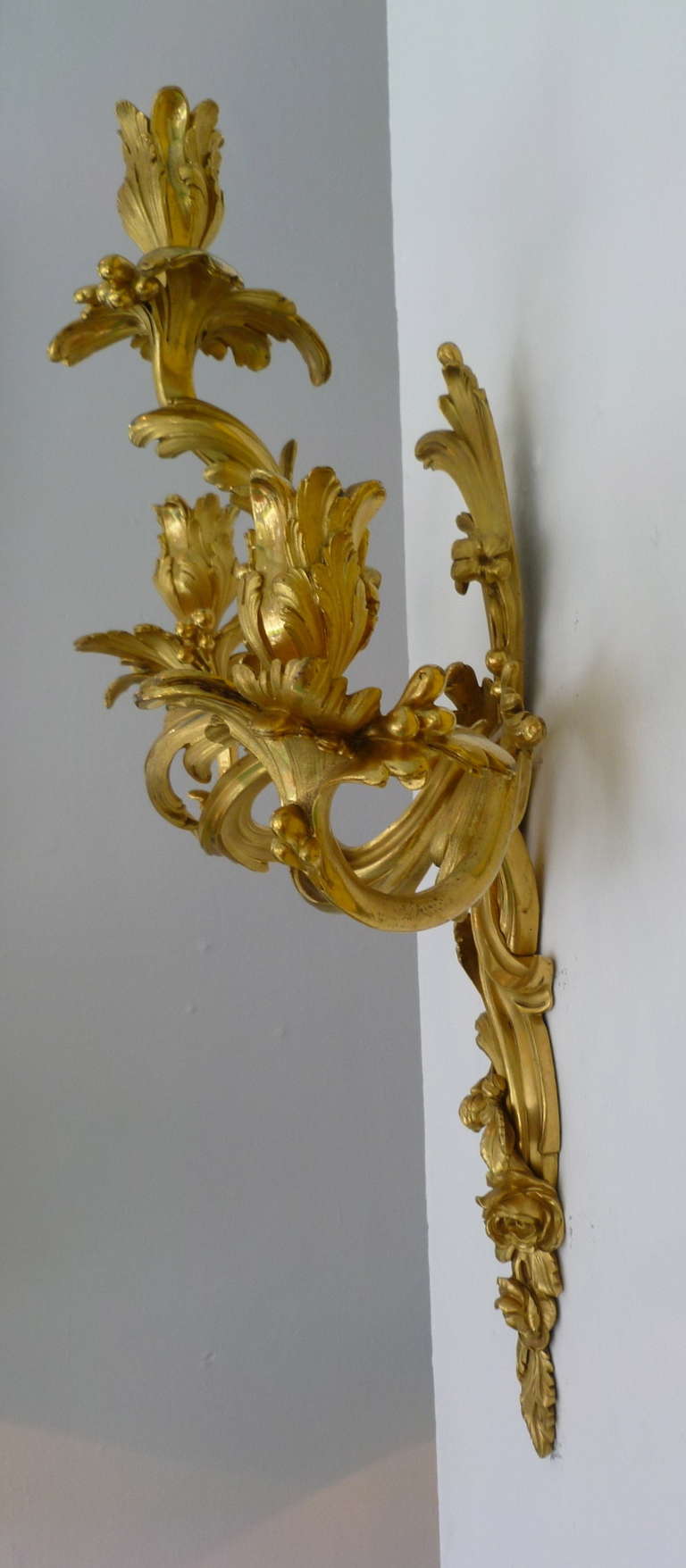 Pair French Louis XV style Rococo ormolu wall sconces in the manner of Jacques Caffieri c.1850
Finely cast and chased, and of the highest quality, these exquisite wall sconces are designed with continuous scrolling foliate branches, terminating in