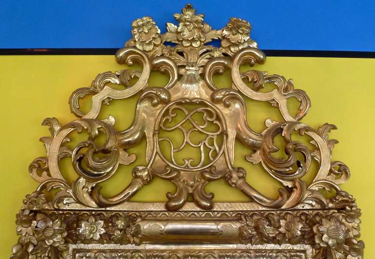 An exquisite early 18th century French Regence gilt wood mirror. The rectangular frame surmounted by a pierced upper section, both profusely carved with floral and foliate motifs.