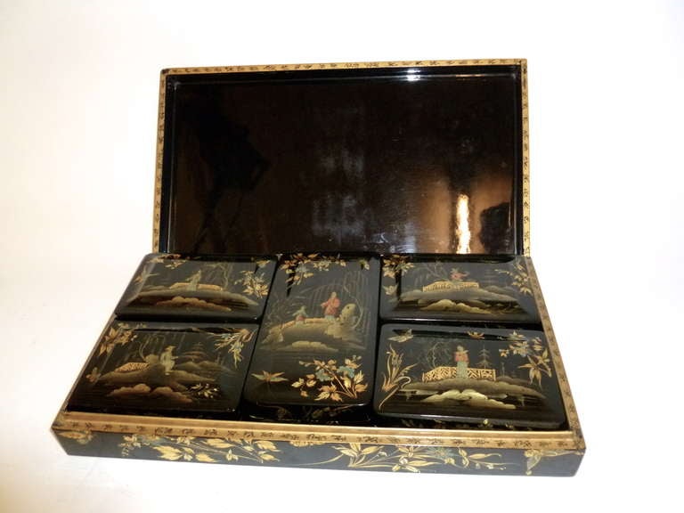 Fabulous papier mâché box c1840, on black lacquer ground with raised gilt and polychrome chinoiserie decoration, and five fitted smaller boxes inside. The outer box depicts four scenes, one in each corner, featuring characters by the waterside,