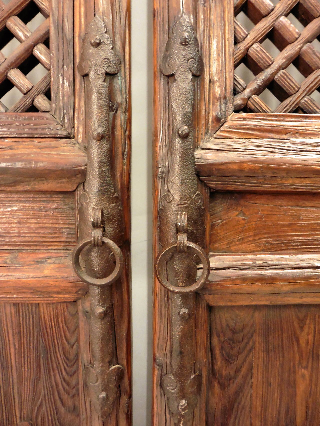 Chinese elm eight panel window lattice screen doors from Shanxi Province 19th Century with circular iron handles.