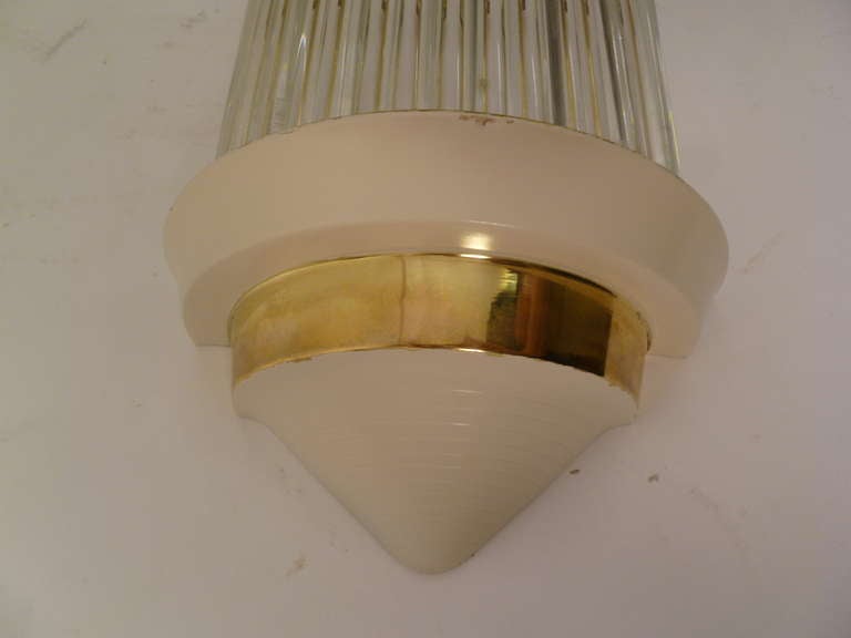 Set four English Art Deco Odeon Style wall lights circa 1930, formed by a series of glass rods, retained by top and bottom caps in brass, and painted metal. This style of wall light was popularized during the first half of the 20th century for use