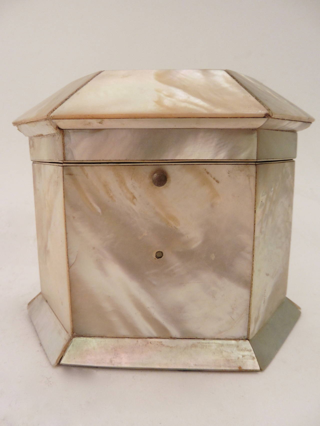 A delightful English Victorian mother-of-pearl veneered tea caddy with an inner tortoiseshell lid topped by a small circular mother-of-pearl handle. The inside lined with patterned orange silk, circa 1850.