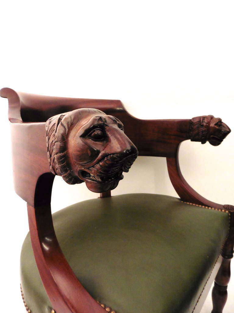A very fine French Empire style mahogany tub desk chair, model of Jacob, circa 1880. The curved back terminating in beautifully carved lion's heads above a green leather seat, on ring turned baluster front legs with brass caps.