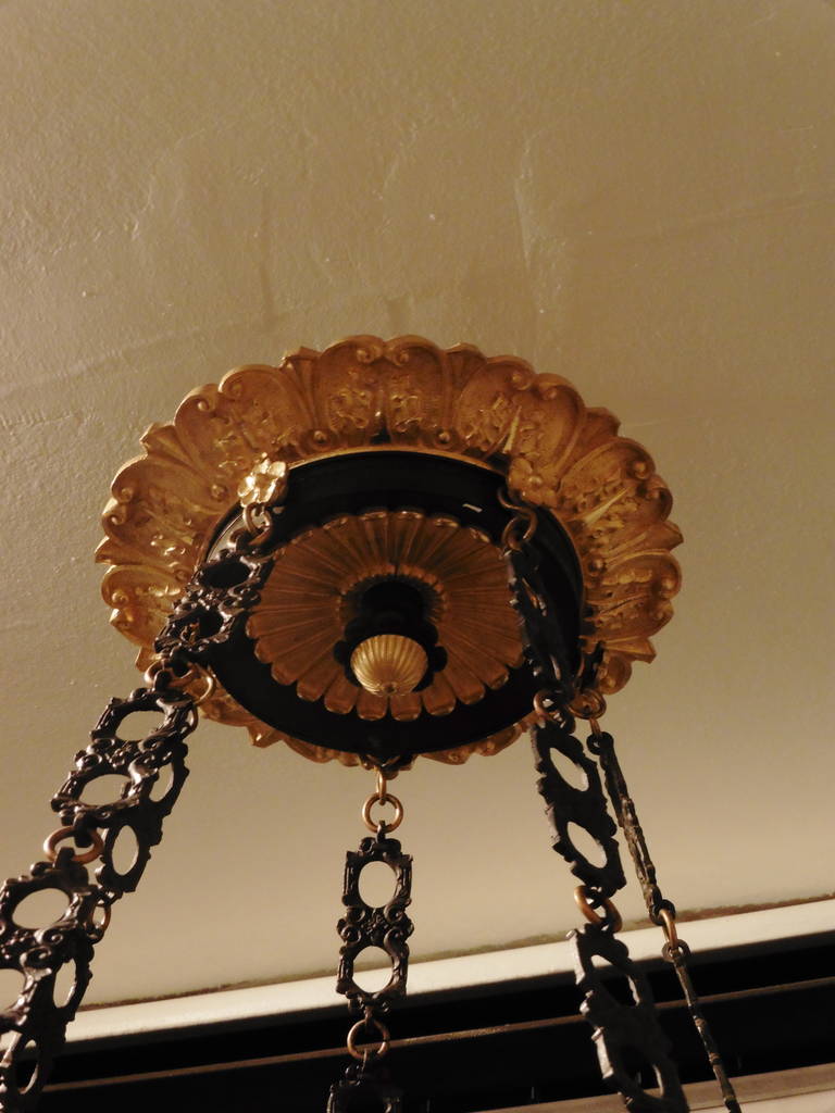 A fine French Empire bronze neoclassical chandelier, circa 1820.
The delightful foliate cast corona issuing decorative bronze chain supports, the spreading body surmounted by a gadrooned urn and flanked by ten finely cast and chased foliate mounts