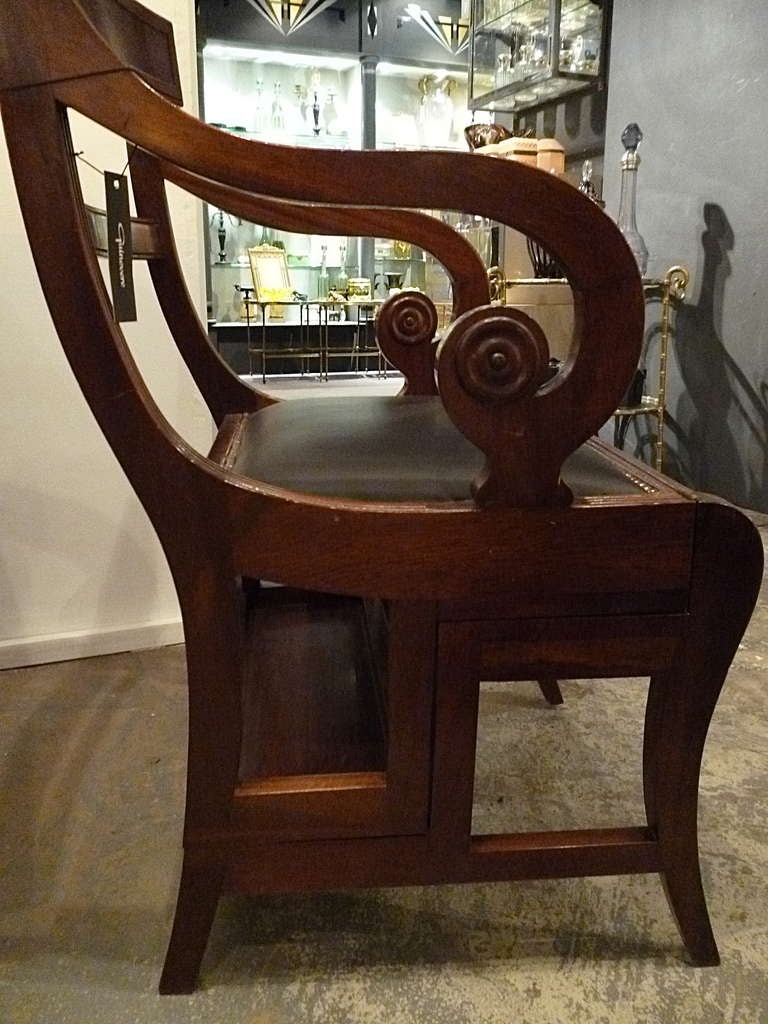 Regency style mahogany metamorphic chair c1930 in the style of Morgan & Sanders.  A rare combination of a leather upholstered library chair. The hinged seat falls forward to form four steps in green leather with gilt trim. With a curved tablet