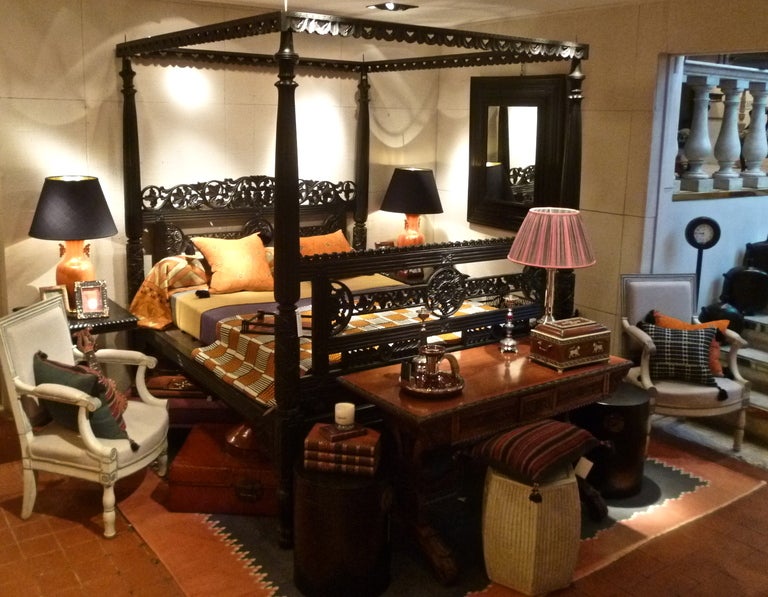 Anglo Indian carved four poster bed in ebonised rosewood circa 19th century from Gujurat. The head and footboards are richly decorated with geometric floral and foliate designs, supported by four turned and carved posts surmounted by a top rail