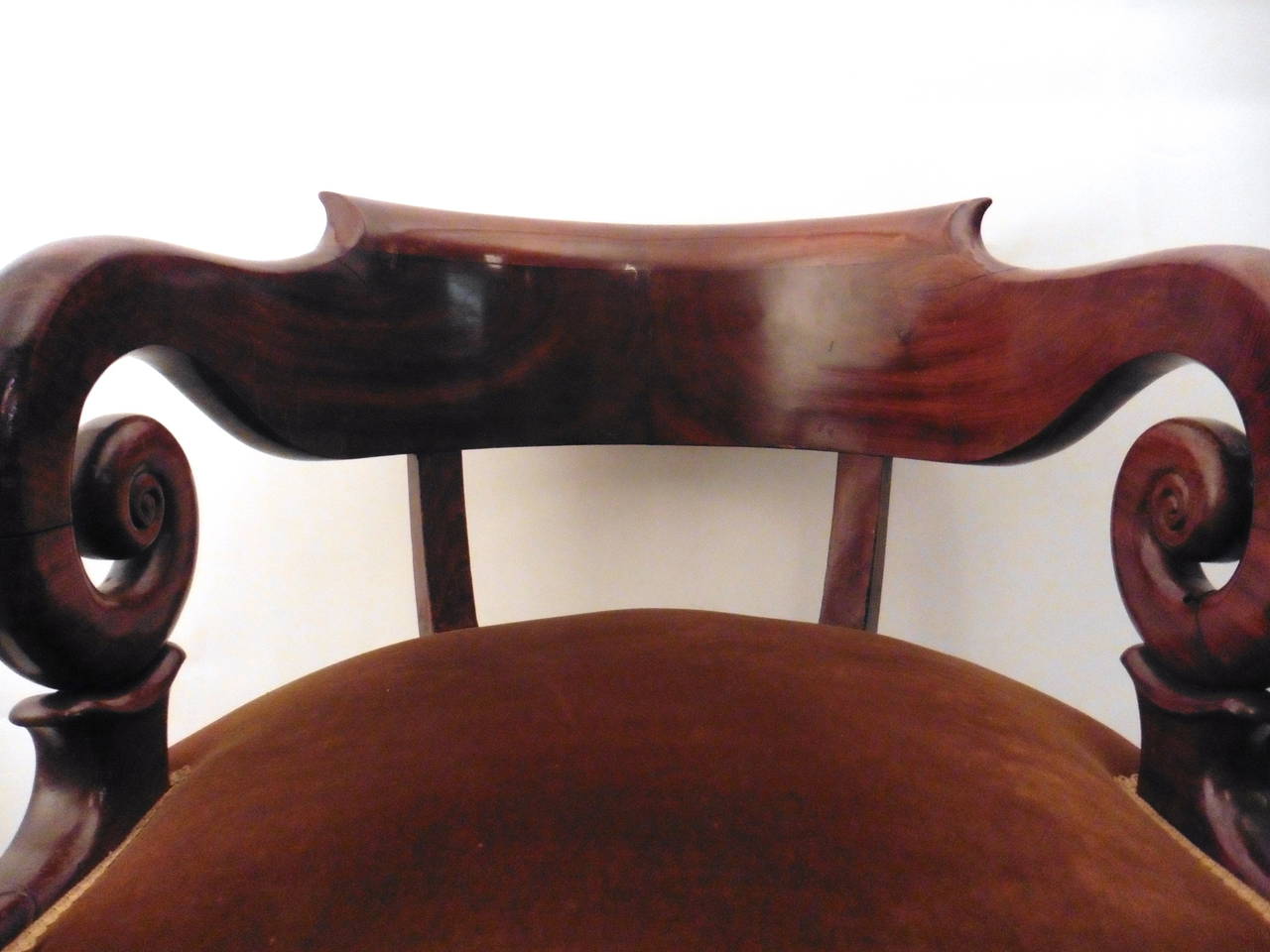 An extremely elegant and finely carved French Louis Philippe mahogany tub back desk chair, circa 1860.
The curved outscrolled back rail with wonderful downswept arms above an upholstered seat raised on cabriole legs with carved volutes at the knee.