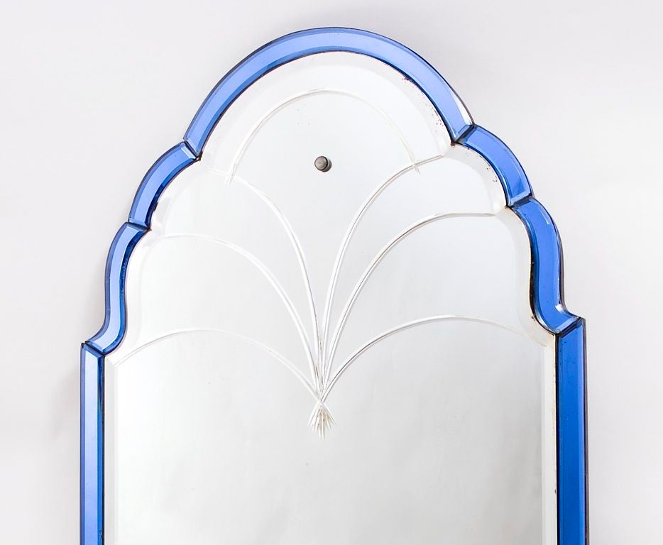 Edwardian Arch top mirror with blue glass border and engraved plate, original wooden back. c1900.<br />
A rectangular arched frame with bevelled mirror plate and foliate engraving, surrounded by divided and bevelled blue frame edging.