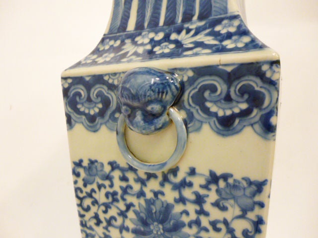 Pair of Chinese Blue & White Porcelain Square Baluster Vases. <br />
The pair of vases are symmetrical, displaying an arabesque middle and cabbage leaf patterned neck. At either sides of the vases are two handle decorations. The handles protrude