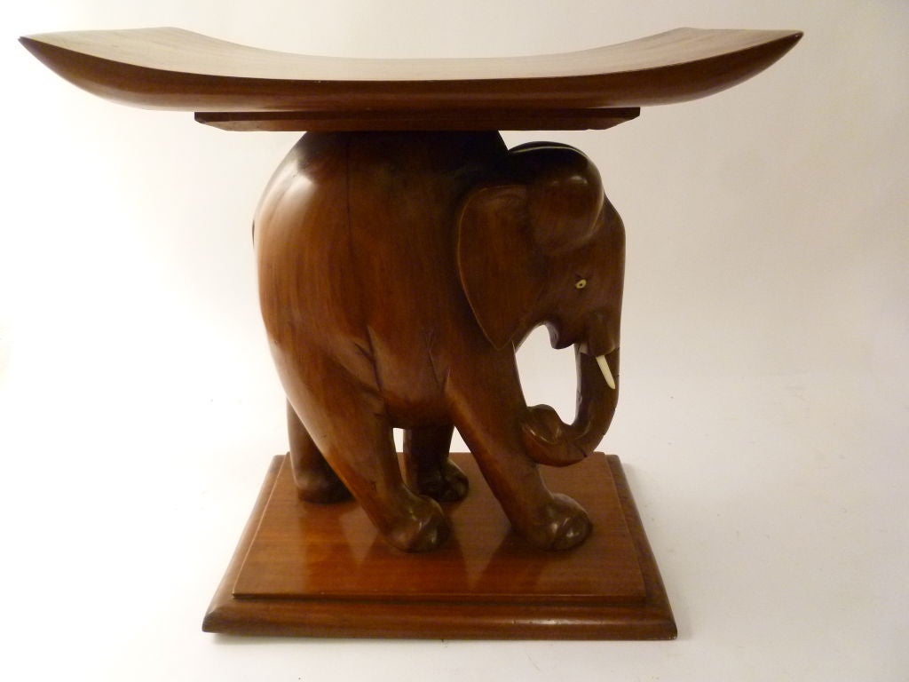 Suite of African Teak and Ivory “Elephant” Furniture - Desk, 4 stools, Coffee Table and Standard Lamp - probably Ivory Coast. <br />
The table tops are supported on the backs of beautifully carved teak wood elephants.<br />
The 'tree trunk' form