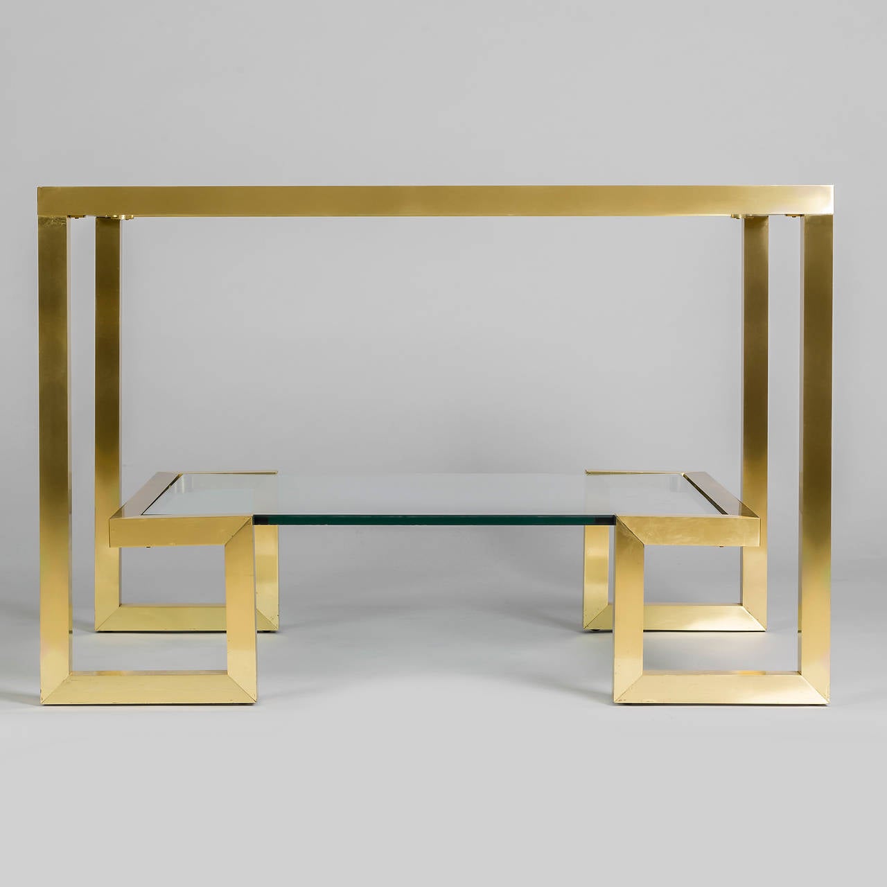 Pair of French 1970s brass console tables with glass top and shelf.