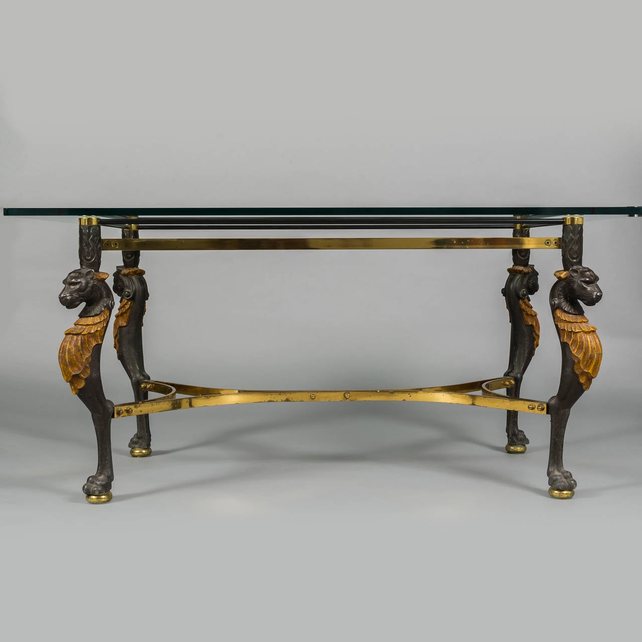 Striking pair of tables with lion motif legs in white metal. Brass details and thick glass tops, French.