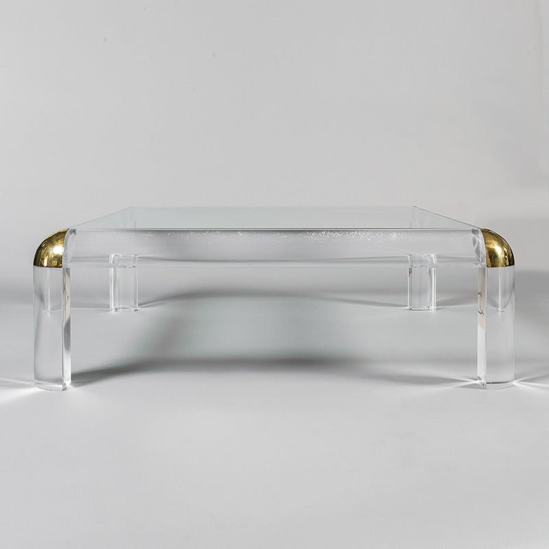 Lucite and glass centre table with brass details, attributed to Maison Jansen, France, circa 1970.

Maison Jansen (House of Jansen) was a Paris-based interior decoration office founded in 1880 by Dutch-born Jean-Henri Jansen and continuing in
