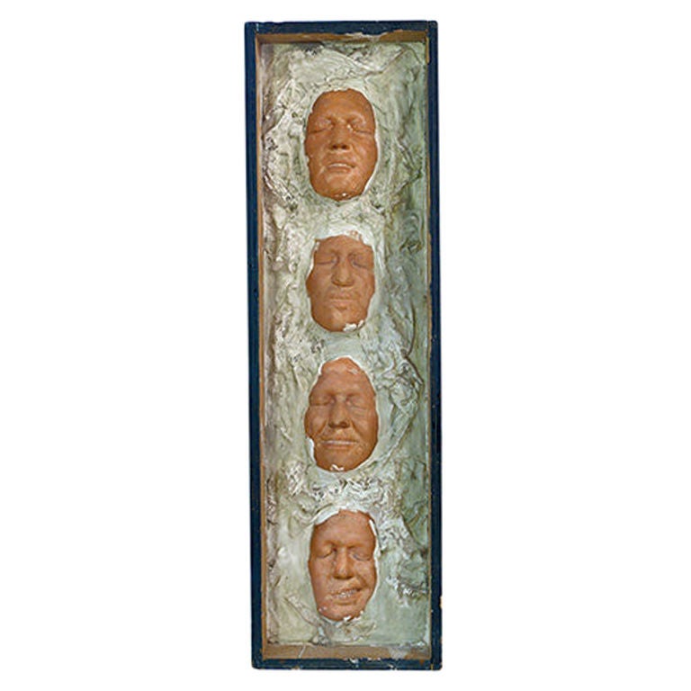 Boxed wall sculpture featuring four resin faces, England, 1940s.