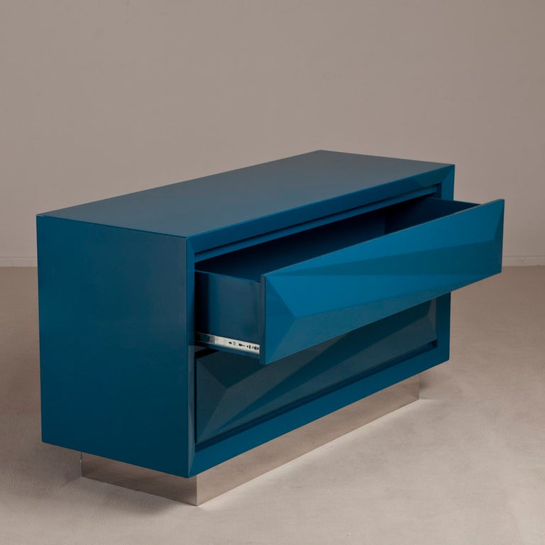 A Standard Teal Lacquered Asymmetrical Two Drawer Commode on Steel Base by Talisman Bespoke. This simple faceted classic design is available in a wide range of lacquer colours (RAL/paint colours can be specified) with either a brass or steel